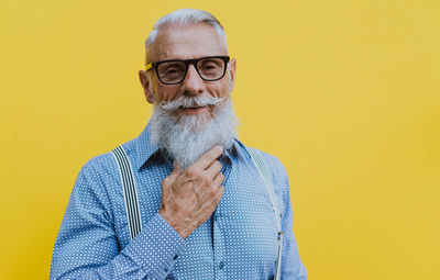 Senior man against yellow background