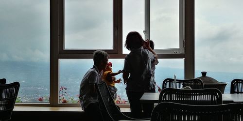 People standing by glass window