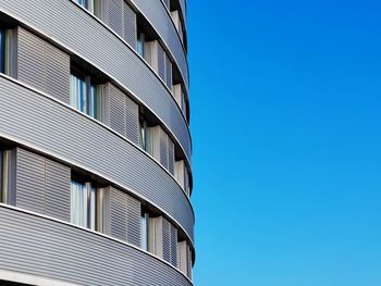 Low angle view of modern building against clear blue sky