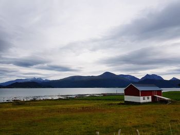 Built structure on field by mountains against sky