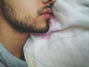 Cropped image of bearded man relaxing on bed