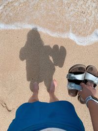 Low section of people standing on beach