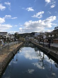 Canal amidst buildings in town against sky