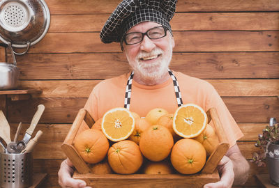 Portrait of senior man holding oranges