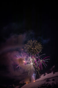 Low angle view of firework display at night