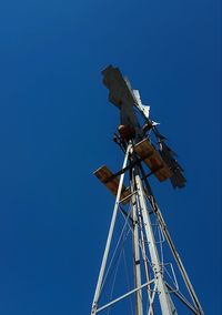 Low angle view of windmill against clear blue sky