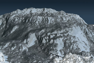 Snow covered rock formation against sky