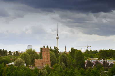 View of buildings in city against cloudy sky