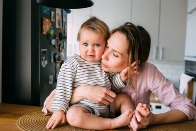 Mom plays at home with a small child on the couch, have fun.