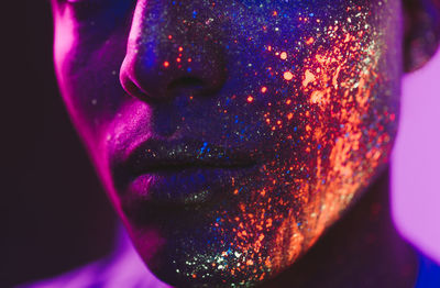 Close-up of man with multi colored face paint