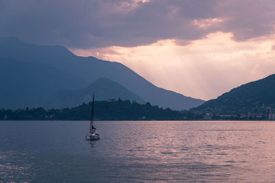 Sailboat in sea against mountains