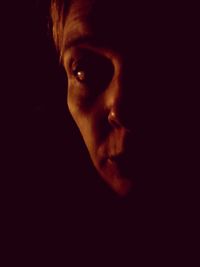 Close-up of serious young woman against black background