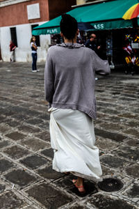 Rear view of woman walking on footpath