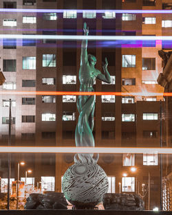 Statue in city at night