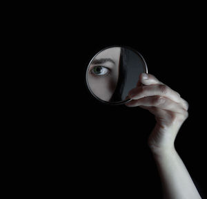 Close-up of human hand against black background
