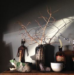 Close-up of vase on table against wall at home