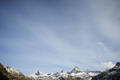 Low angle view of snowcapped mountains against sky