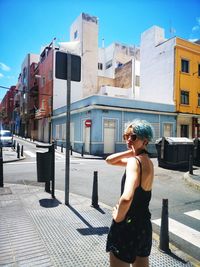 Side view of man standing on street against buildings