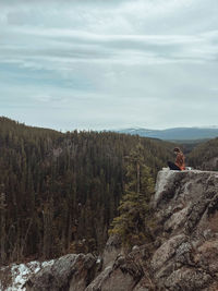 Rear view of man walking on mountain against sky