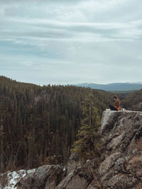 Woman sitting on the top of a mountain and enjoying the view 