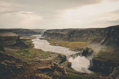 Scenic view of waterfall against sky