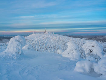 Snow covered field against sky