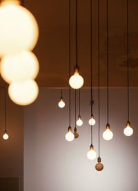 Low angle view of illuminated pendant light hanging from ceiling