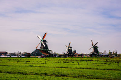 Traditional windmill on field against sky