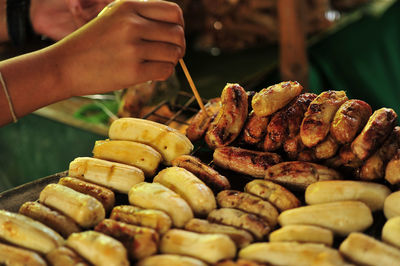 Close-up of person preparing food on barbecue grill