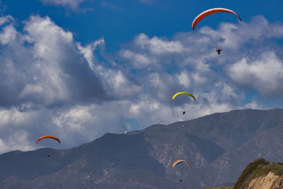 Low angle view of person paragliding against sky