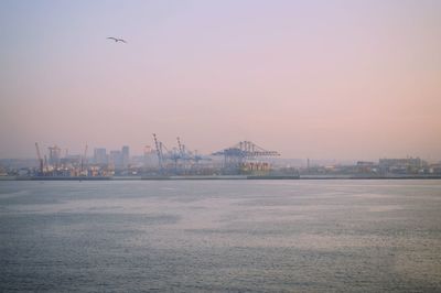 View of commercial dock by sea against clear sky