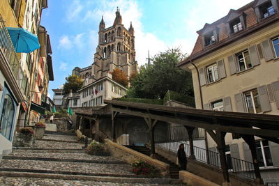 Stairway leading to the cathedral, amidst buildings in lausanne city against sky