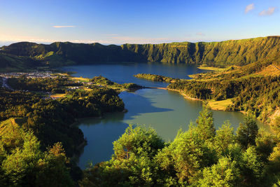 Scenic view of lake by trees against sky