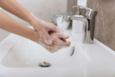 Washing hands under the flowing water tap. washing hands with soap for corona virus prevention