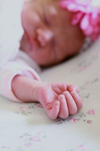 Close-up of baby hand on bed