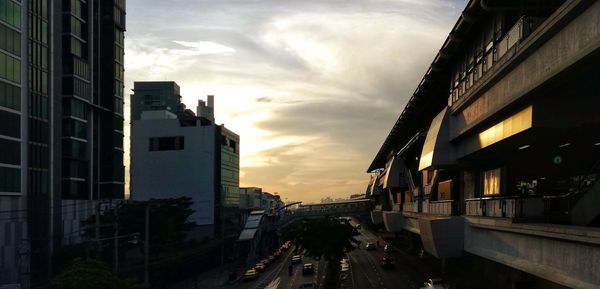 Street amidst buildings against sky during sunset