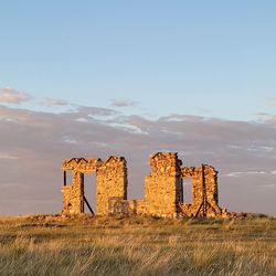 Old ruin on field against sky