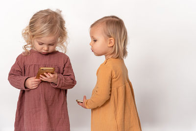 Two little girls looking at mobile phone