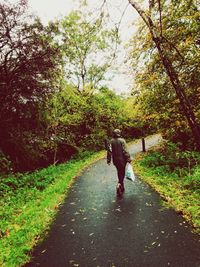 Rear view of woman walking on road