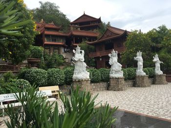 Statue against trees and building