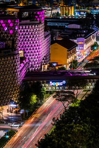 High angle view of light trails on road amidst buildings at night