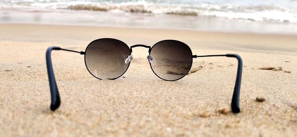 Close-up of sunglasses on beach