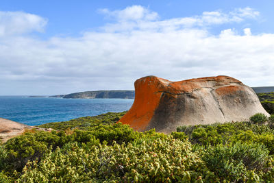 Rock formations by sea against sky