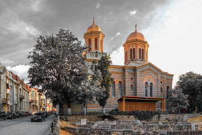 Cathedral by buildings against sky in city