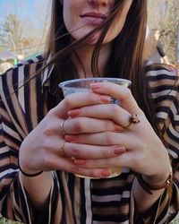 Midsection of woman holding glass