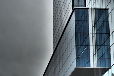 Low angle view of glass building against sky