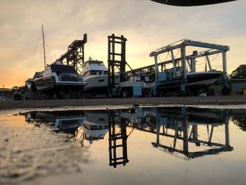 Boats at harbor against sky during sunset