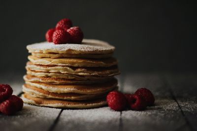 Close-up of stacked pancakes with raspberries on table