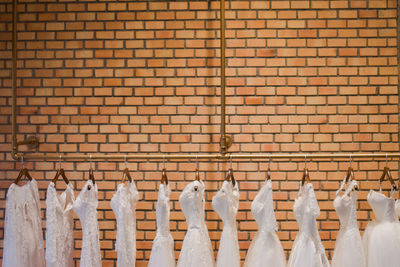 Dresses hanging against brick wall