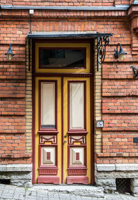 Red wooden door with glass in a red brick building in europe. architectural theme
